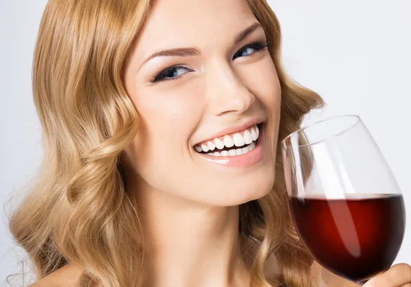 Giovane donna felice con bicchiere di vino rosso, su grigio — Foto Stock