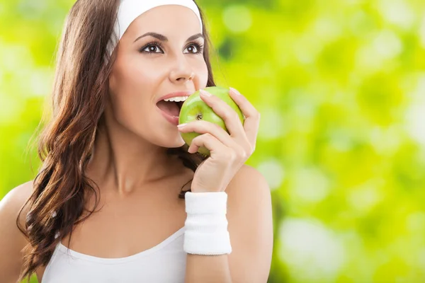 Mujer en ropa de fitness con manzana, al aire libre —  Fotos de Stock