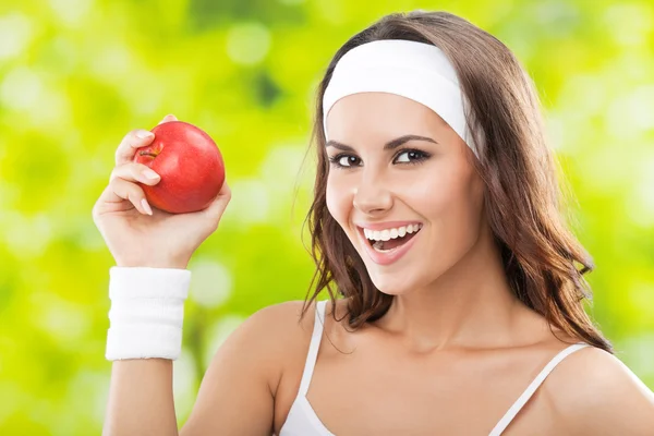 Mujer en ropa de fitness con manzana, al aire libre —  Fotos de Stock