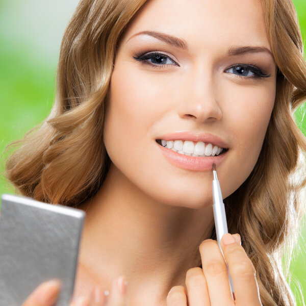 Smiling woman with make up brush, outdoor