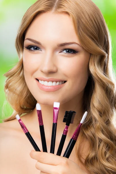 Smiling woman with make up tools, outdoor — Stock Photo, Image