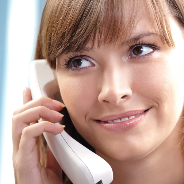 Jeune femme avec téléphone, au bureau — Photo