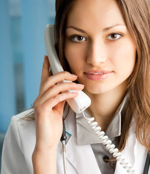 Jeune médecin au téléphone, au bureau — Photo