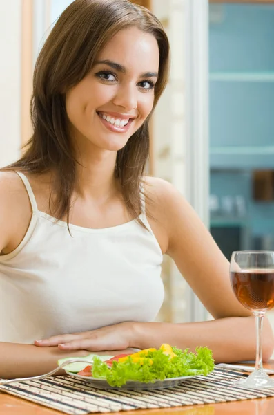 Mulher alegre com copo de vinho tinto e salada — Fotografia de Stock