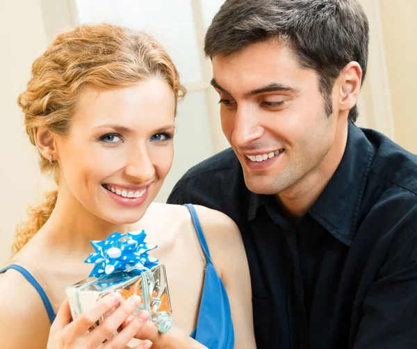 Casal amoroso alegre com presentes, dentro de casa — Fotografia de Stock