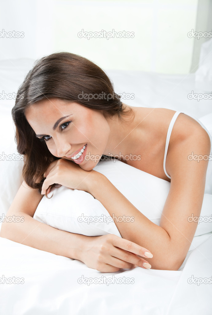 Young beautiful woman waking up, at bedroom
