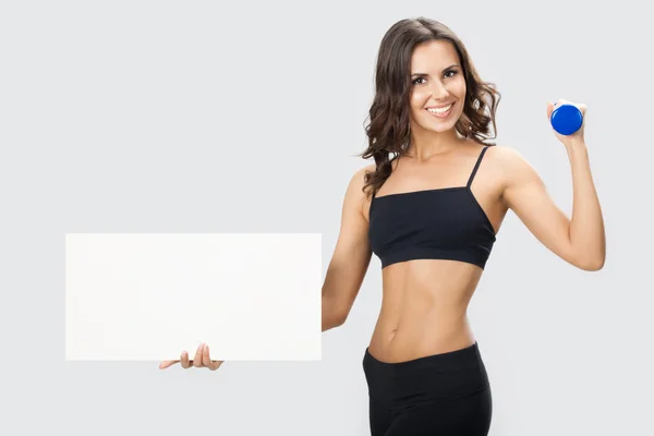 Woman in fitnesswear showing signboard, over grey — Stock Photo, Image