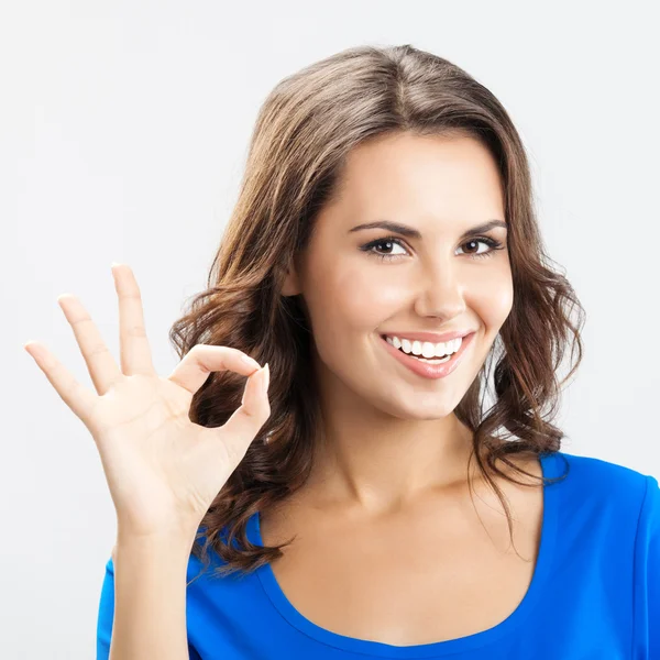 Junge Frau zeigt okay Geste, über grau — Stockfoto