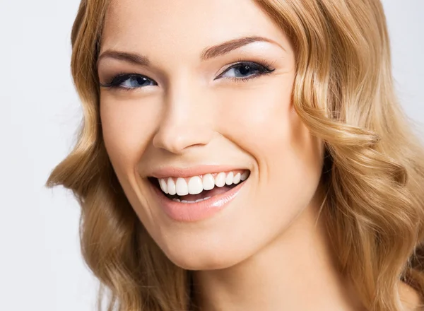 Joven mujer sonriente alegre, en gris — Foto de Stock