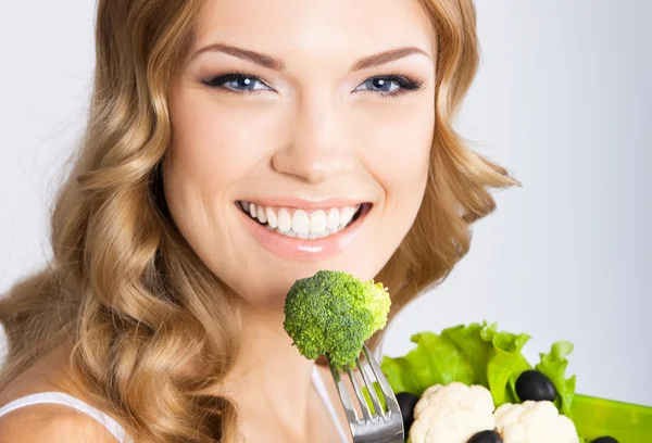 Kvinna med vegetarisk sallad, över grå — Stockfoto