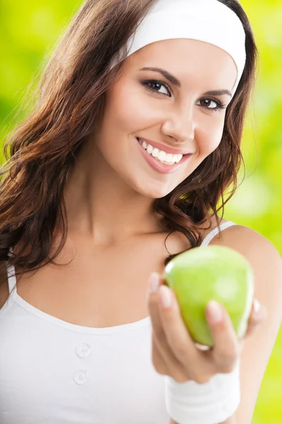 Frau in Fitnessbekleidung mit Apfel, im Freien — Stockfoto