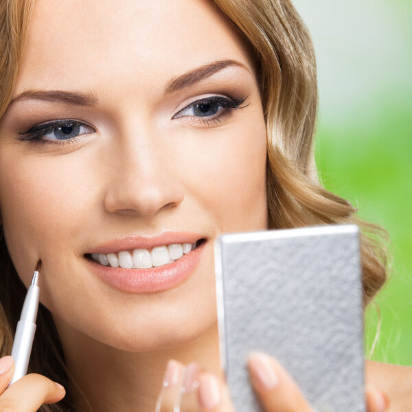 Smiling woman with make up brush, outdoor