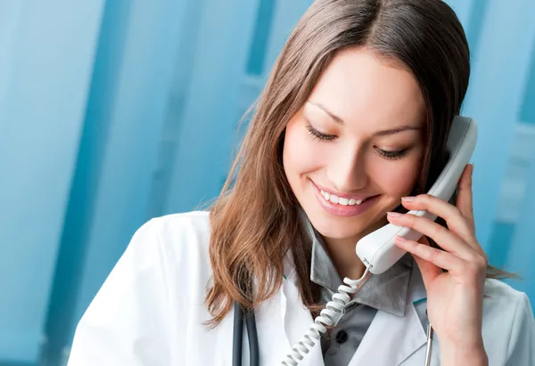 Young doctor on phone, at office Stock Picture