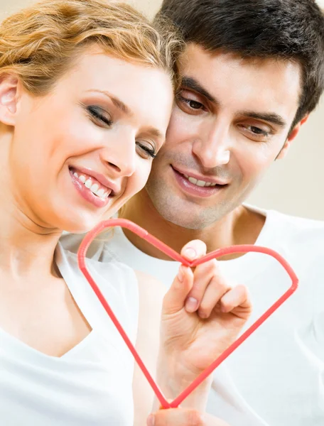 Young amorous couple with heart symbol — Stock Photo, Image