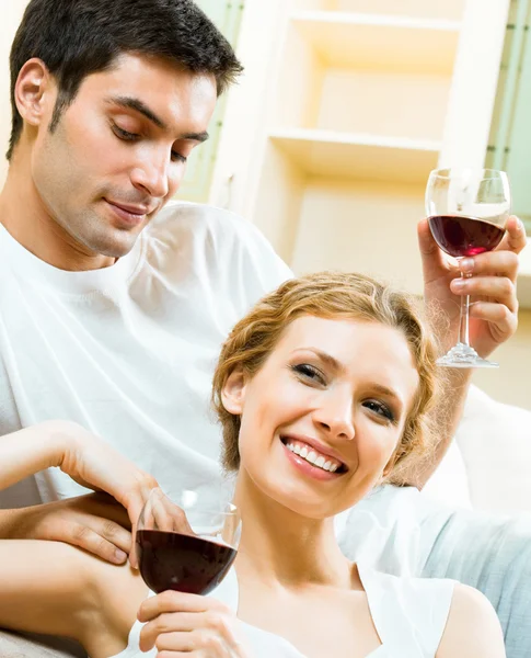 Casal alegre com copos de vinho tinto — Fotografia de Stock