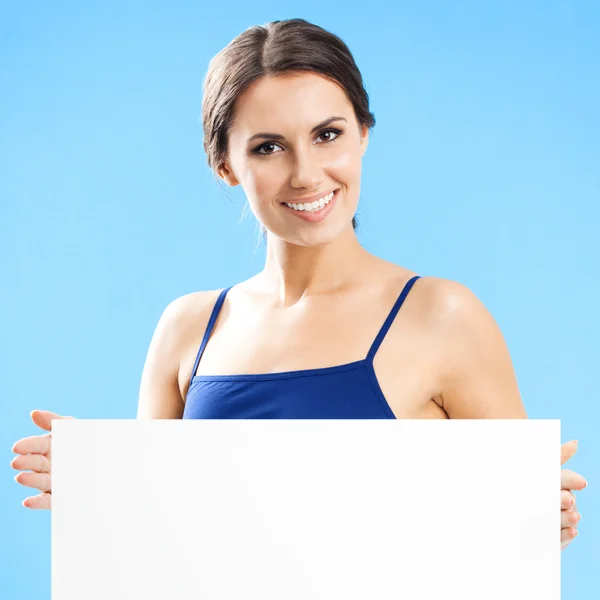 Frau in Fitnessbekleidung zeigt Schild, über blau — Stockfoto