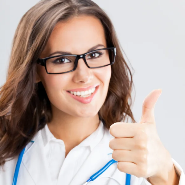 Medico femminile con i pollici in su gesto, sopra grigio — Foto Stock