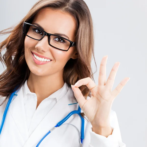 Medico donna con gesto positivo, sopra grigio — Foto Stock