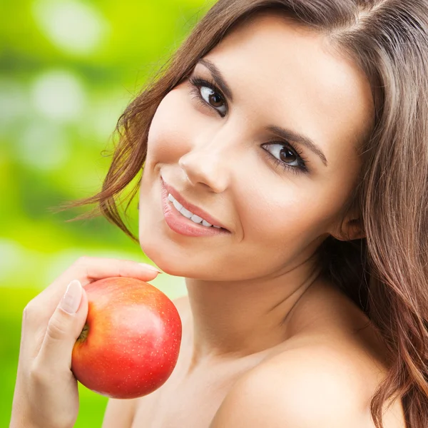 Jonge vrouw met rode appel, buitenshuis — Stockfoto