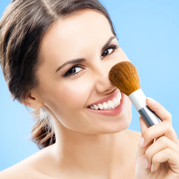 Woman with cosmetics brush, on blue — Stock Photo, Image