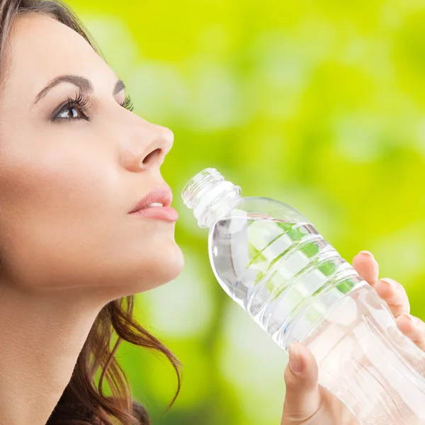Mujer joven bebiendo agua, al aire libre — Foto de Stock