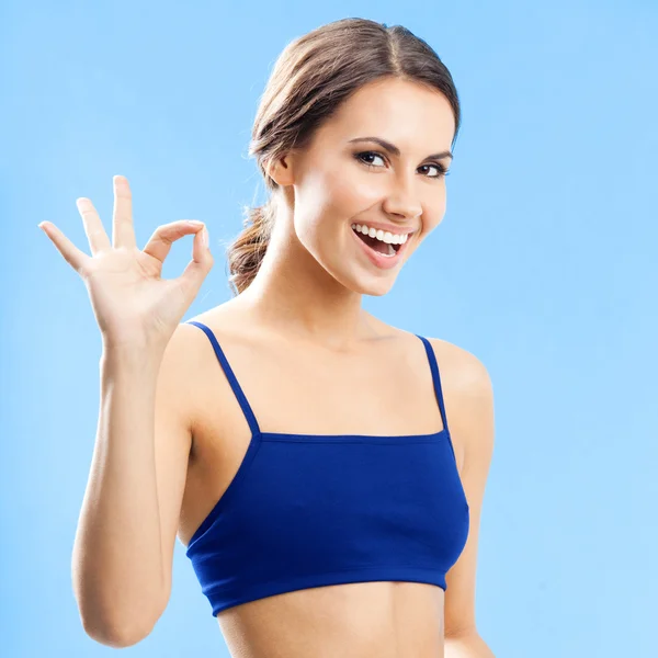 Cheerful woman in fitness wear, on blue — Stock Photo, Image