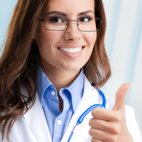 Doctor showing thumbs up gesture, at office — Stock Photo, Image