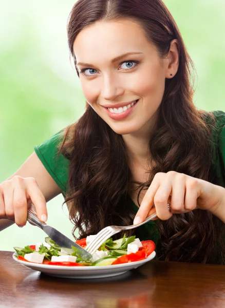 Retrato de mulher sorridente feliz comendo salada no prato, ao ar livre — Fotografia de Stock