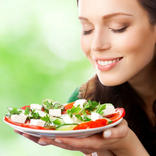 Portrait of happy smiling woman with plate of salad Stock Picture