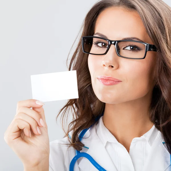 Boş iş kartı gösteren genç bir kadın doktor — Stok fotoğraf