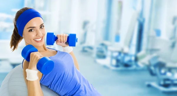 Joven mujer feliz haciendo ejercicio físico, en el gimnasio —  Fotos de Stock