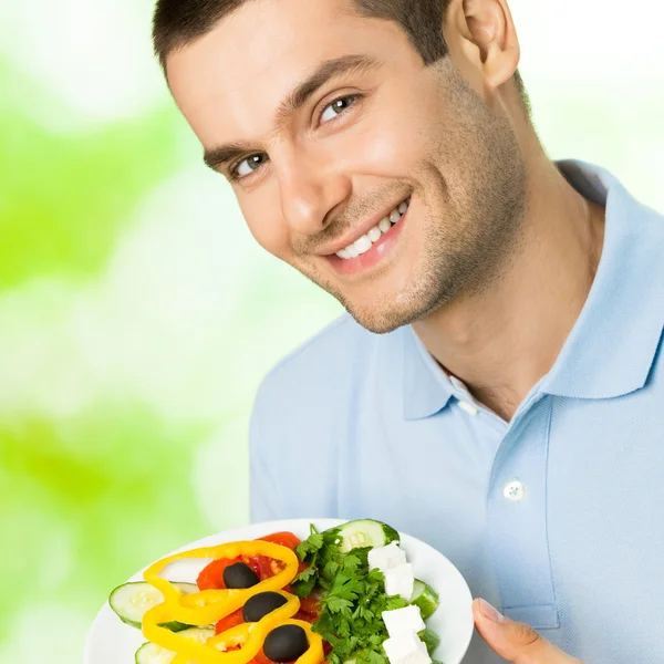 Portret van lachende man met plaat van salade, buiten — Stockfoto