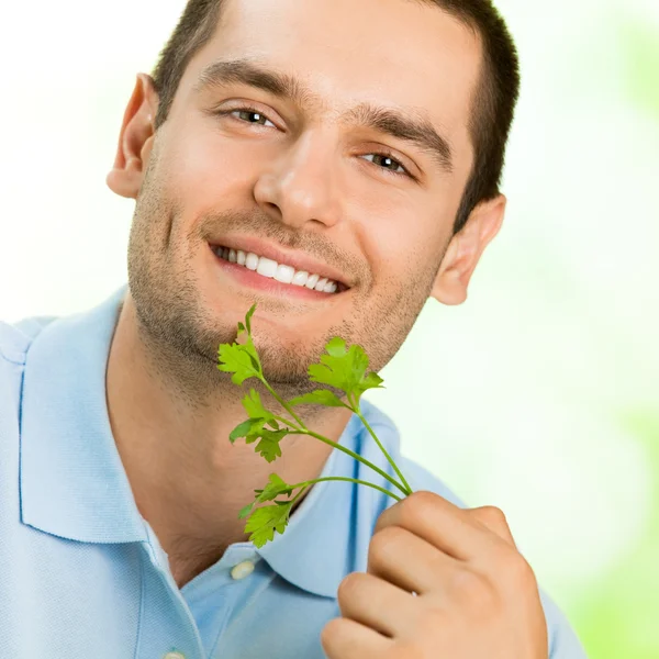 Joven hombre sonriente con potherbs —  Fotos de Stock