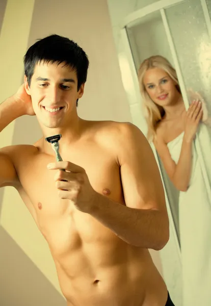 Afeitado hombre y mujer joven en el baño — Foto de Stock