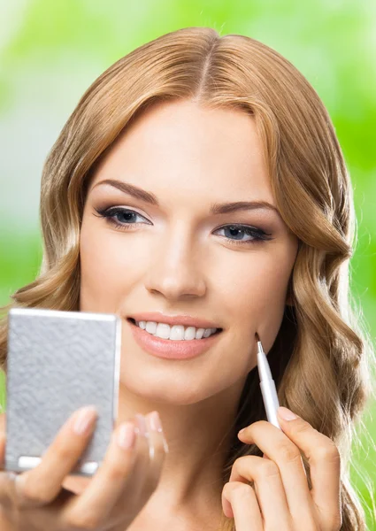 Mujer sonriente con cepillo de maquillaje, al aire libre — Foto de Stock