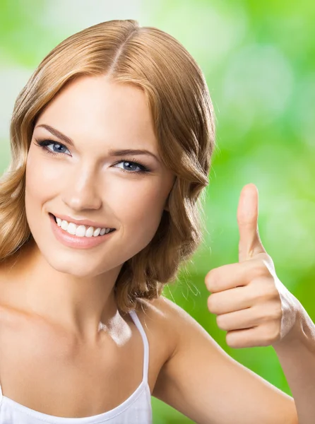 Happy woman with thumbs up gesture, outdoor — Stock Photo, Image