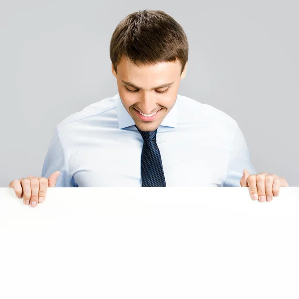 Business man showing blank signboard, over gray — Stock Photo, Image