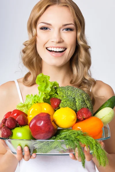 Mujer joven con comida vegetariana, sobre gris — Foto de Stock