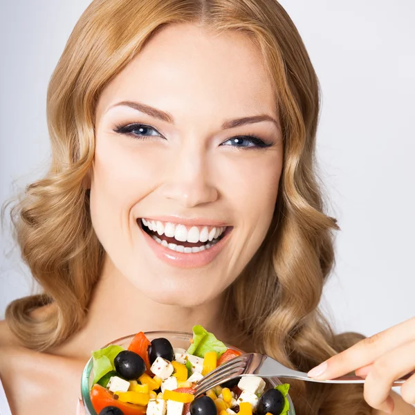 Kvinna med vegetarisk sallad, över grå — Stockfoto