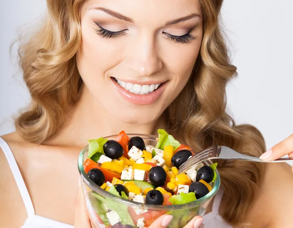 Mulher com salada vegetariana, sobre cinza — Fotografia de Stock