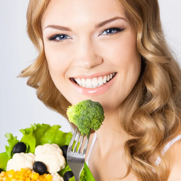 Femme avec salade végétarienne, sur gris — Photo