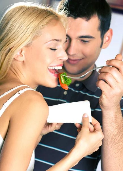 Unga attraktiva glada leende par äta lekfullt vegetabiliska — Stockfoto