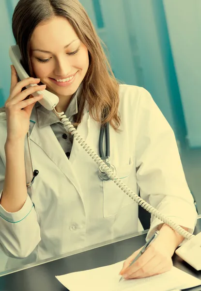 Jeune médecin au téléphone, au bureau — Photo