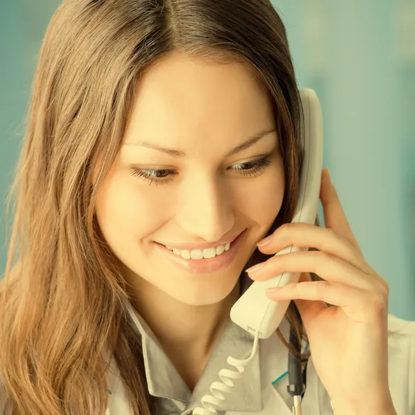 Jeune médecin au téléphone, au bureau — Photo