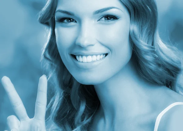 女性は、2 本の指または勝利のジェスチャーを示す — ストック写真