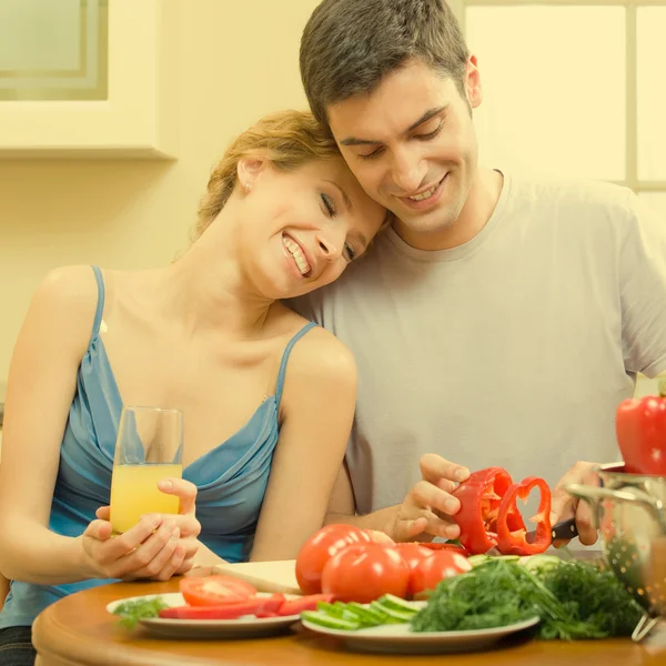 Cheerful young cooking couple at home — Stockfoto