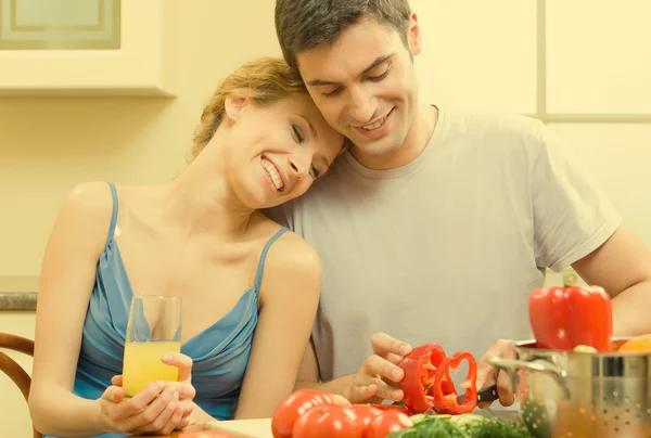 Cheerful young cooking couple at home — Stockfoto