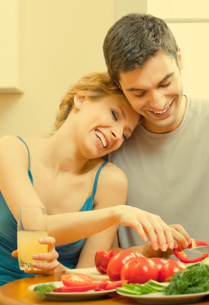 Cheerful young cooking couple at home Royalty Free Stock Images