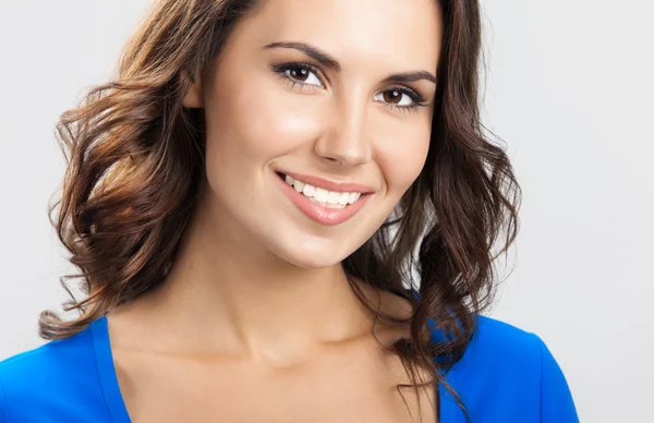 Happy smiling young woman, over grey — Stock Photo, Image