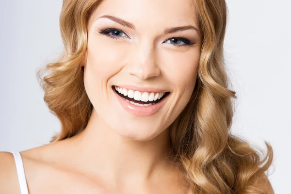 Jovem mulher sorridente alegre, em cinza — Fotografia de Stock